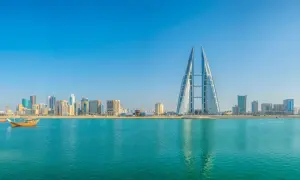 Manama Skyline mit dem Bahrain World Trade Center und traditionellen Dhaus-Booten am Khalifa Bin Salman Port.