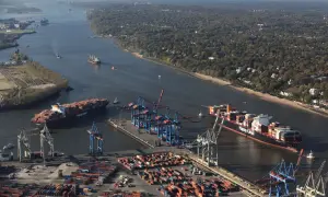 Große Containerschiffe navigieren durch die Elbe, ein Zeichen für die Bedeutung der deutschen Häfen im globalen Handel.