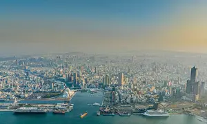 Blick über die Stadt und den geschäftigen Kaohsiung Port mit Schiffen und Containern.