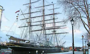Ein majestätischer clipper ship liegt im Hafen, seine Masten ragen in den Himmel.