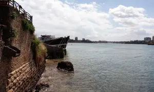 Ein Schiff liegt im Hafen von Mombasa vor Anker. Die Steinküste und Gebäude im Hintergrund zeugen von der geschäftigen Atmosphäre.