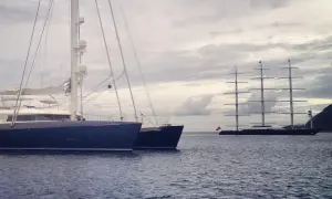Ein großes, modernes Segelboot liegt neben einem historischen Segelschiff. Ein beeindruckender boat vs ship Vergleich.