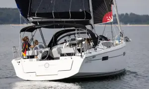 Segelboot mit schwarzem Großsegel und Besatzung, die an das Erbe von Eric Tabarly erinnert.