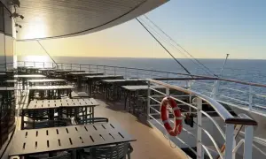 Leere Tische und Stühle auf einem Kreuzfahrtschiff-Deck bei Sonnenuntergang, bereit für die Gäste nach den marine surveys.