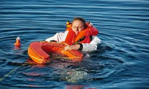 Frau im Wasser mit Schwimmweste und Rettungsring, ein "man overboard" Szenario.