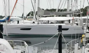 Eine moderne Segelyacht, die Excess 14, liegt im Hafen. Ihr elegantes Design und die großen Fenster versprechen Komfort.