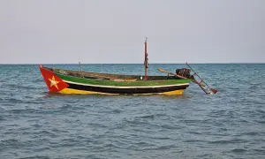 Ein bunt bemalenes Fischerboot treibt auf ruhiger See. Rot, gelb und grün zieren den Rumpf, ein Stern prangt am Bug.