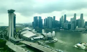 Blick auf die Skyline von Singapur mit dem Marina Bay Sands Hotel, dem ArtScience Museum und dem geschäftigen Singapore Port im Hintergrund.