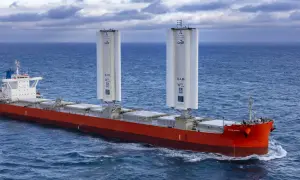 Frachtschiff mit zwei großen Windrotoren für umweltfreundliches tailwind shipping auf dem Meer.