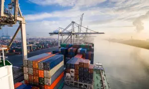 Containerriese in einem geschäftigen Hafen, ein Symbol für europäische Häfen und globalen Handel.