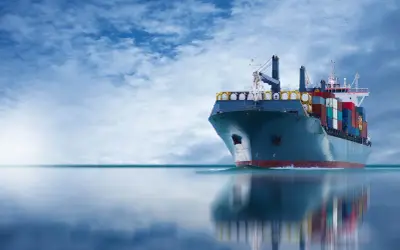 Frachtschiff mit Containern auf See, das die Einhaltung des IMDG-Codes für den sicheren Transport gefährlicher Güter demonstriert.