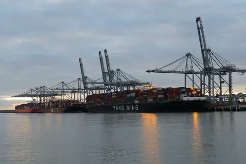 Große Containerschiffe liegen im Hafen unter Kränen, mit dem Schriftzug "YANG MING".