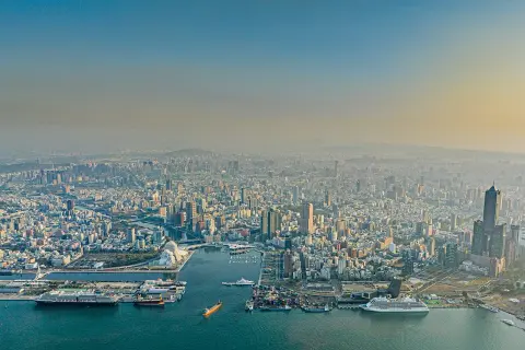 Blick über die Stadt und den geschäftigen Kaohsiung Port mit Schiffen und Containern.