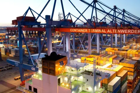 Containerhafen Altenwerder bei Dämmerung. Kräne und Containerstapel, die auf die **spot rates** für den globalen Handel warten.