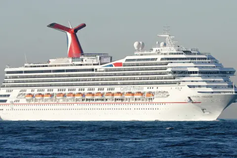 Das Kreuzfahrtschiff Carnival Freedom gleitet über das Meer. Die roten Rettungsboote sind bereit für den Carnival-Spaß.