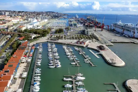 Blick auf den geschäftigen Lissabon Port mit vielen Segelbooten und einem Kreuzfahrtschiff.