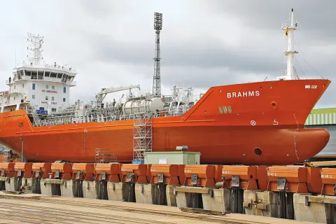 Orange product tanker "BRAHMS" in dry dock, ready for maintenance.