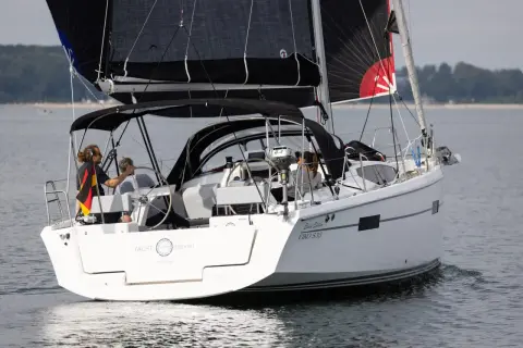 Segelboot mit schwarzem Großsegel und Besatzung, die an das Erbe von Eric Tabarly erinnert.