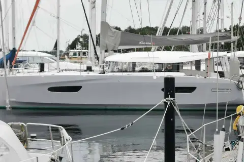 Eine moderne Segelyacht, die Excess 14, liegt im Hafen. Ihr elegantes Design und die großen Fenster versprechen Komfort.