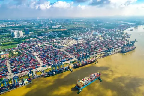 Ein riesiger Containerhafen, der Cat Lai Port, mit tausenden von Containern und Schiffen, die auf dem Fluss liegen.