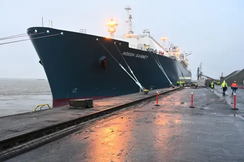 Das Schiff "Hoegh Gannet" liegt im Hafen. Arbeiter in Warnwesten sind auf dem Kai.