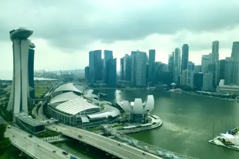 Blick auf die Skyline von Singapur mit dem Marina Bay Sands Hotel, dem ArtScience Museum und dem geschäftigen Singapore Port im Hintergrund.