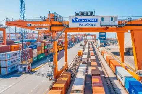 Ein geschäftiger Hafen mit Kränen, Containern und Zügen. Die "Luka Koper Port of Koper" ist bereit für den nächsten telex release.