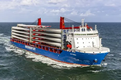Ein **heavy lift vessel** transportiert viele Rotorblätter für Windkraftanlagen über das Meer.