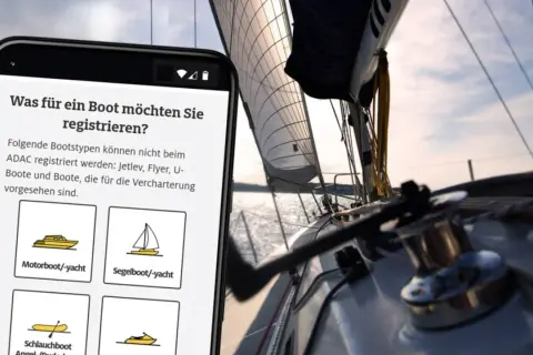 Smartphone zeigt Bootsregistrierung, während ein Segelboot auf dem Wasser fährt. Kein Hinweis auf eine Flag of convenience.