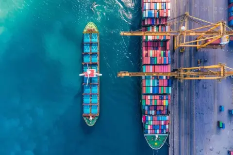 Große Containerschiffe im Hafen, bereit für den **time charter**. Kräne laden und löschen bunte Fracht.