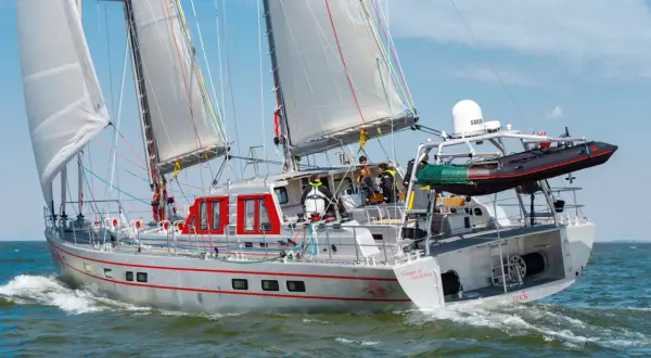 Segelboot "Vinson of Antarctica" auf dem offenen Meer. Die pelagic 77 gleitet durch die Wellen, die Crew ist an Deck beschäftigt.