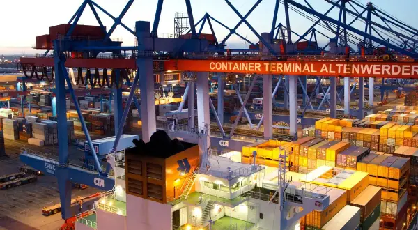 Containerhafen Altenwerder bei Dämmerung. Kräne und Containerstapel, die auf die **spot rates** für den globalen Handel warten.