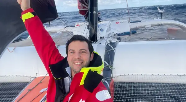 Guirec Soudée jubelt auf seinem Katamaran auf hoher See.