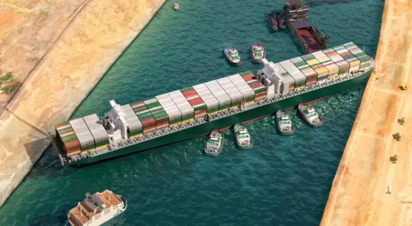 Ein Containerschiff wird von mehreren Schleppern durch einen Kanal manövriert. Der allgemeine Durchschnitt der Frachtschifffahrt.