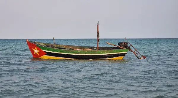 Ein bunt bemalenes Fischerboot treibt auf ruhiger See. Rot, gelb und grün zieren den Rumpf, ein Stern prangt am Bug.