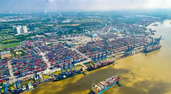 Ein riesiger Containerhafen, der Cat Lai Port, mit tausenden von Containern und Schiffen, die auf dem Fluss liegen.