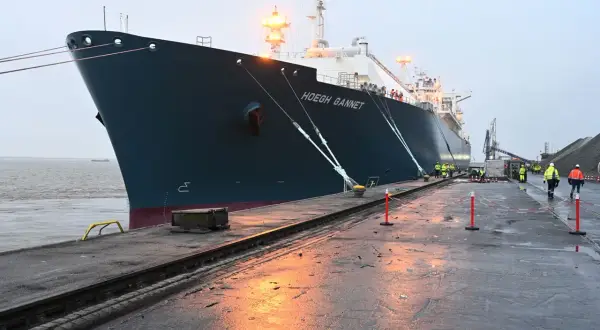 Das Schiff "Hoegh Gannet" liegt im Hafen. Arbeiter in Warnwesten sind auf dem Kai.