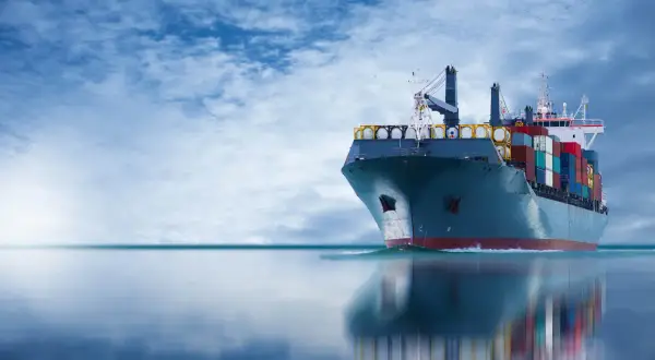 Frachtschiff mit Containern auf See, das die Einhaltung des IMDG-Codes für den sicheren Transport gefährlicher Güter demonstriert.