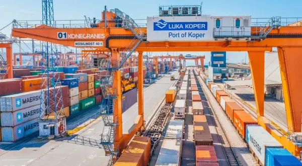 Ein geschäftiger Hafen mit Kränen, Containern und Zügen. Die "Luka Koper Port of Koper" ist bereit für den nächsten telex release.