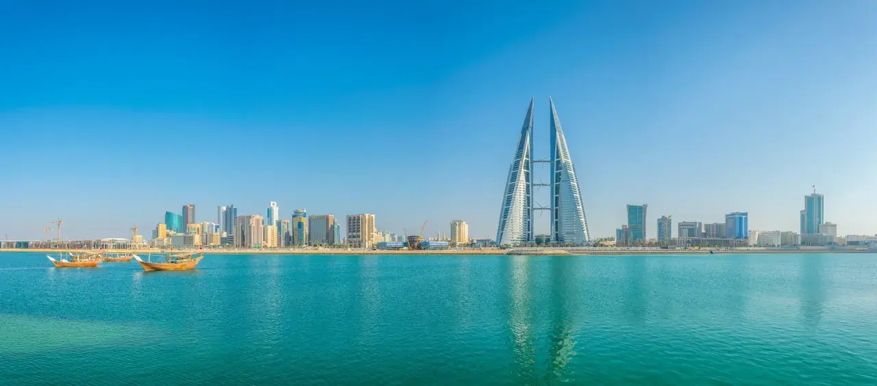 Manama Skyline mit dem Bahrain World Trade Center und traditionellen Dhaus-Booten am Khalifa Bin Salman Port.