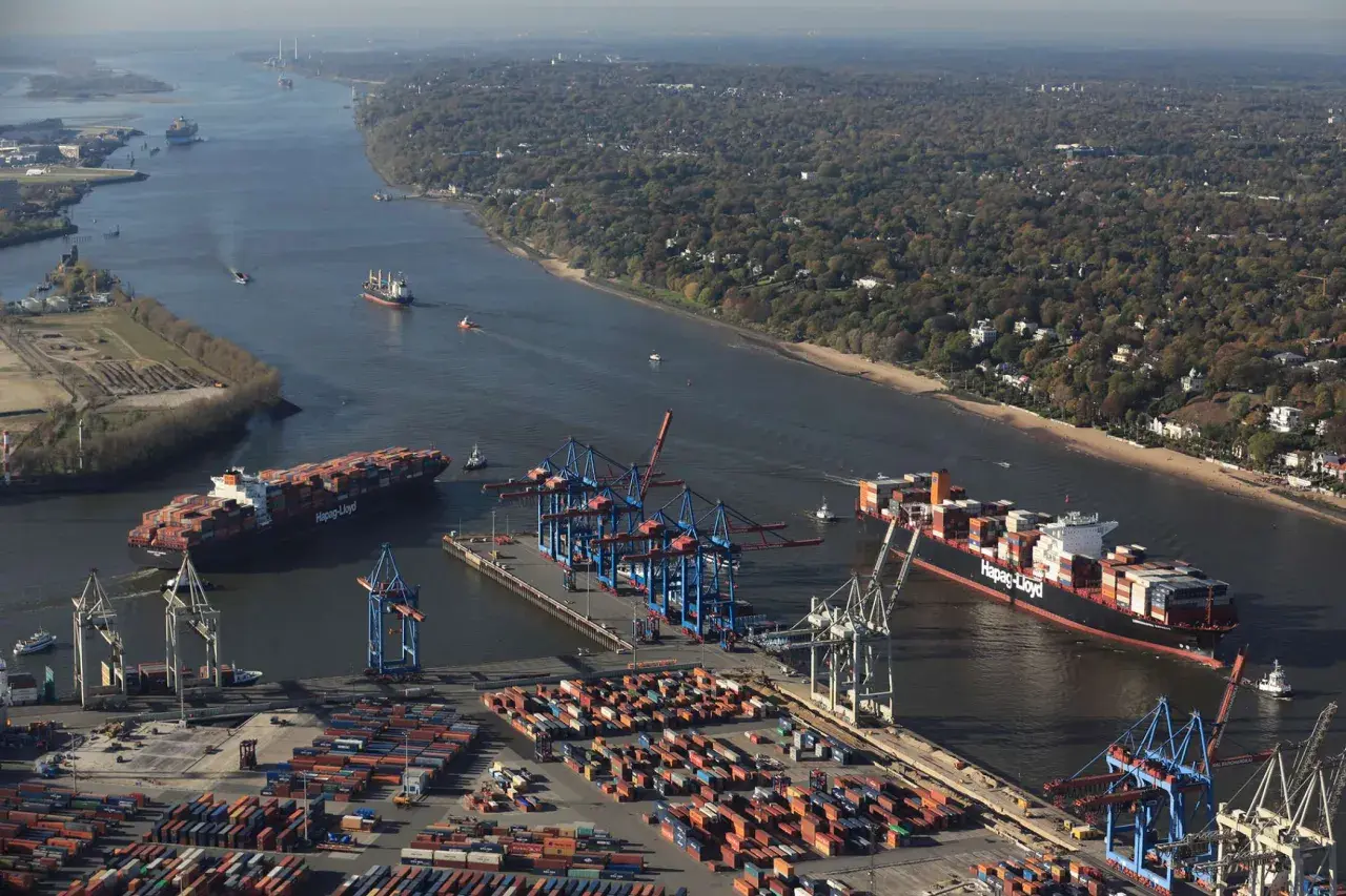 Große Containerschiffe navigieren durch die Elbe, ein Zeichen für die Bedeutung der deutschen Häfen im globalen Handel.