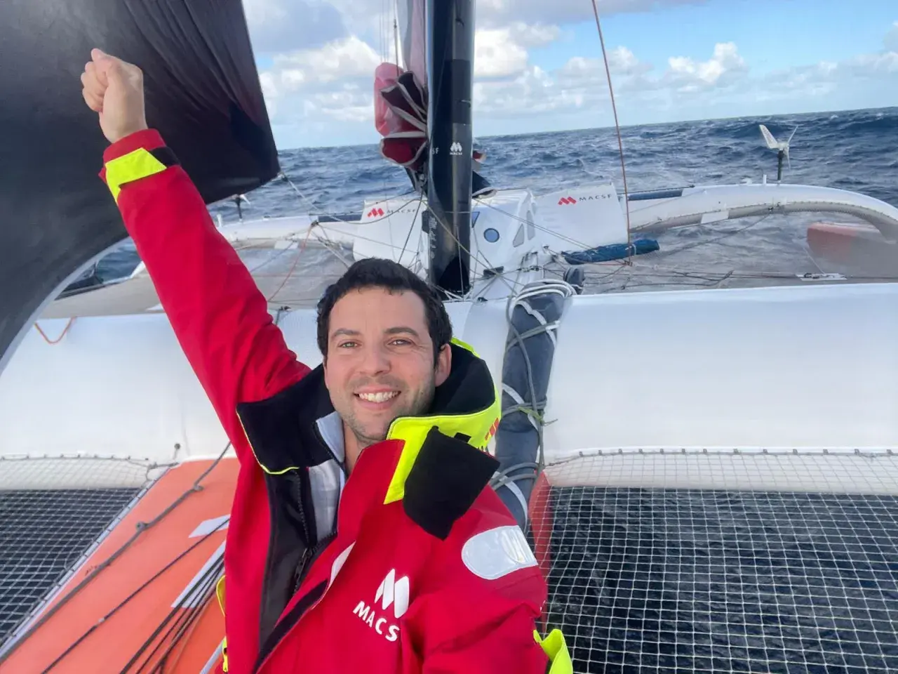 Guirec Soudée jubelt auf seinem Katamaran auf hoher See.