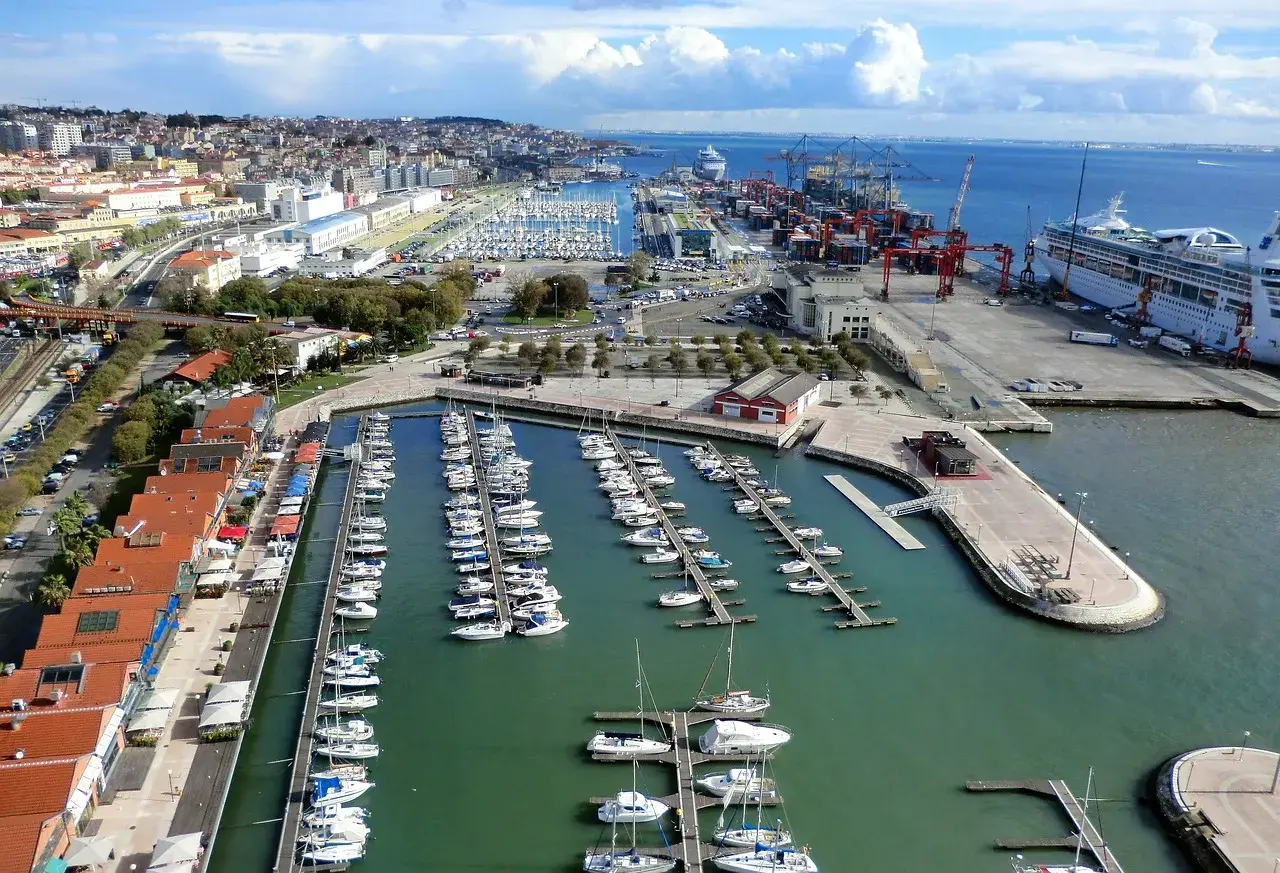 Blick auf den geschäftigen Lissabon Port mit vielen Segelbooten und einem Kreuzfahrtschiff.