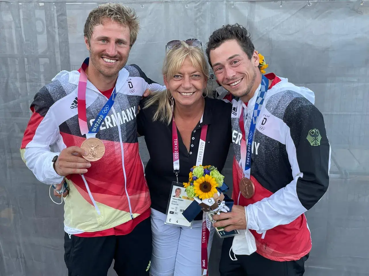 Tatjana Pokorny mit zwei Medaillengewinnern des Team Deutschland bei den Olympischen Spielen in Tokio.