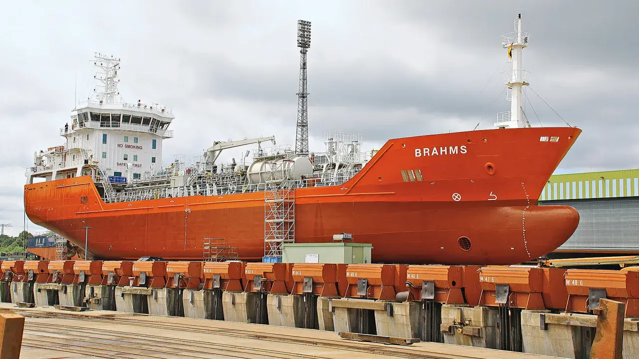 Orange product tanker "BRAHMS" in dry dock, ready for maintenance.