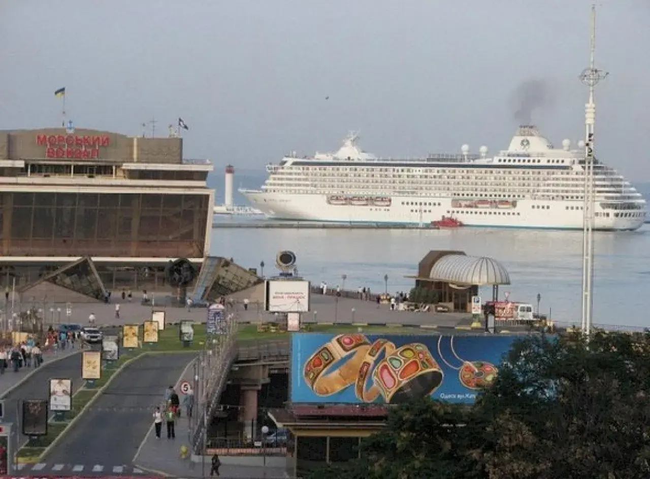 Großes Kreuzfahrtschiff verlässt den odessa port. Ein Leuchtturm wacht über die Einfahrt.