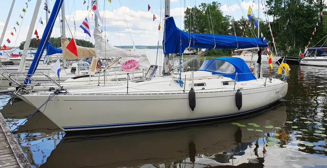 Weiße Segelboote liegen im Hafen, geschmückt mit bunten Flaggen. Eines trägt den Namen "Lady C" und die Kennung "DDL 07". Ein **omega 36**-Boot, bereit für die nächste Ausfahrt.