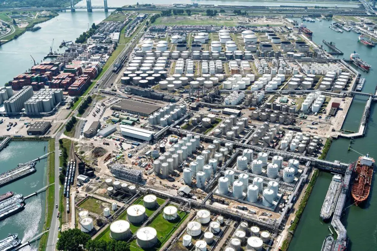Luftaufnahme eines riesigen Hafens mit vielen Tanks und Containern. Der Shuwaikh Port ist ein wichtiger Umschlagplatz für Güter.