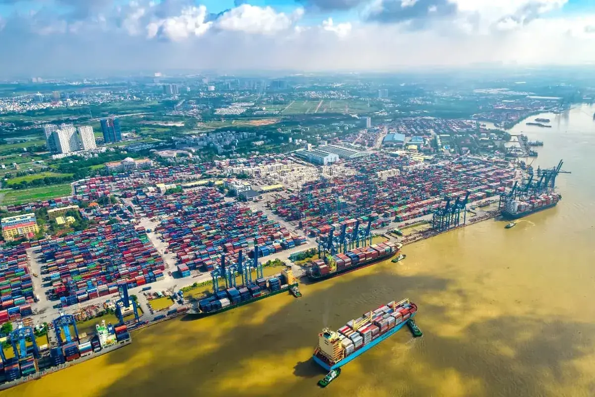 Ein riesiger Containerhafen, der Cat Lai Port, mit tausenden von Containern und Schiffen, die auf dem Fluss liegen.
