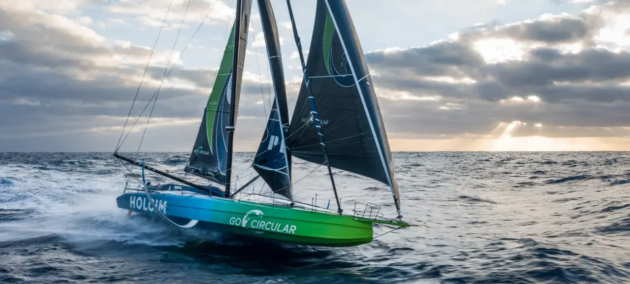 Das team holcim segelt mit voller Kraft über die Wellen. Die Segel sind mit "Go Circular" beschriftet.